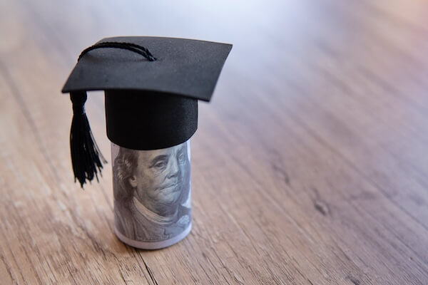 a small graduation cap on top of US currency tax prep checklist